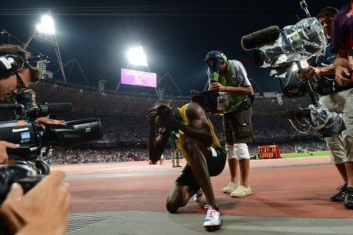 Jamaica's Usain Bolt takes pictures after winning gold in the men's 200m final
